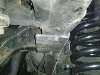 1995 Ford Bronco - A custom bracket is welded onto the suspension system of a vehicle.