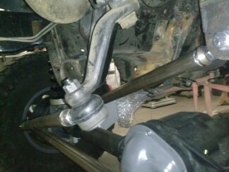 1995 Ford Bronco - Undercarriage view of steering linkage and suspension parts with SUPERMOTORS watermark.