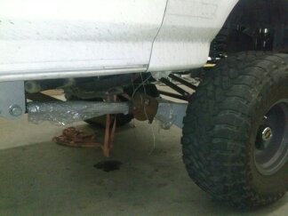 1995 Ford Bronco - Undercarriage view of a vehicle, highlighting the suspension system and a large tire. Text from SuperMotors.net is visible.