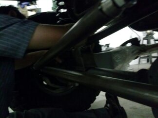 1995 Ford Bronco - A person works on the undercarriage of a vehicle, with a Supermotors logo in the corner.