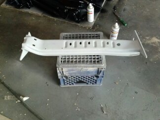 1995 Ford Bronco - A single automotive part is shown, resting on a crate with spray cans and tools in the background.