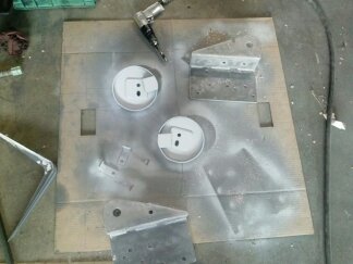 1995 Ford Bronco - Various metal components are laid out on cardboard, ready for painting, with an air tool nearby.