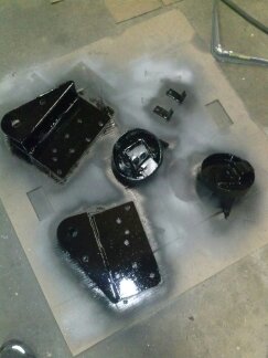 1995 Ford Bronco - Painted metal parts laid out on cardboard, with Supermotors.net logo at the bottom.
