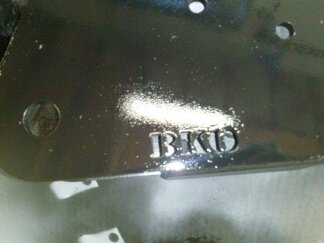 1995 Ford Bronco - A close-up view of a metal component the embossed letters 'BKD'.