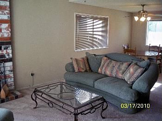 Living room scene with a blue couch and glass coffee table