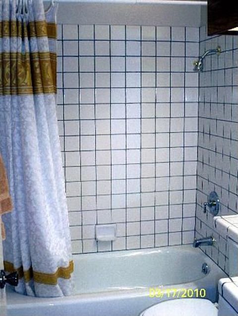 1989 Ford Bronco - A bathroom scene a bathtub, tiled walls, and a decorative shower curtain. A date stamp is visible on the tub.