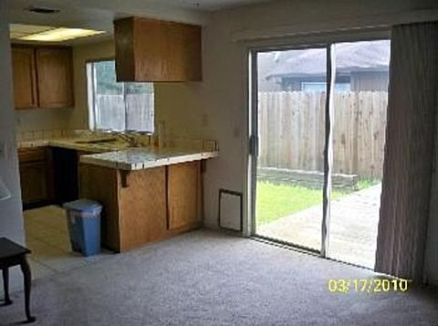 1989 Ford Bronco - A view of a kitchen area with wooden cabinets and a sliding glass door opening to a backyard. A date stamp reads 03/17/2010.