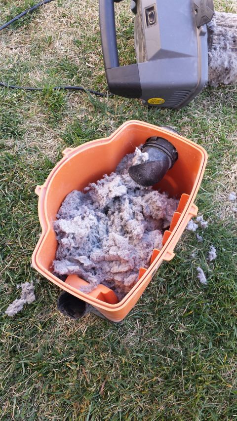 1989 Ford Bronco - A full lint trap and a vacuum cleaner sit on the grass, indicating a recent cleaning or maintenance task.