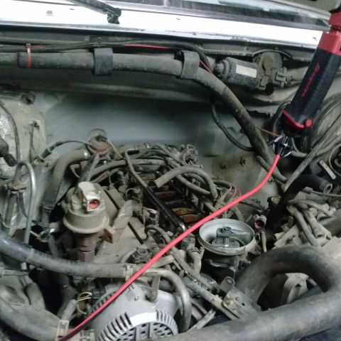 1995 Ford Bronco - Engine bay details showing wiring, hoses, and a work light.