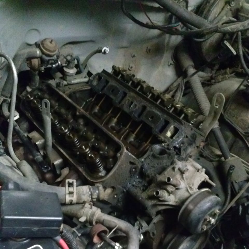 Engine bay with exposed valve covers and wiring. Grimy and appears to be in a state of repair
