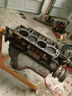 1995 Ford Bronco - An engine block is mounted on a stand in a garage setting, with tools visible in the background.