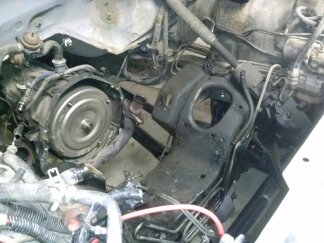 1995 Ford Bronco - Close-up view of the engine bay, focusing on the transmission and associated components. The SuperMotors.net logo is present in the lower r…