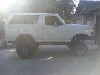1995 Ford Bronco - This white Ford Bronco SUV appears to be from the early to mid-1990s, with a lifted suspension and large off-road tires.