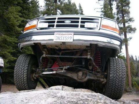 1995 Ford Bronco - Front view of a 1995 Ford Bronco on a rocky trail, highlighting its suspension system.