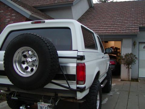 1995 Ford Bronco - This SUV, likely a 1992 Ford Bronco, is parked outside a suburban garage.