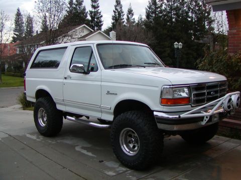 1995 Ford Bronco - A lifted 1995 Ford Bronco is shown from a three-quarter front angle, modified for off-road use.