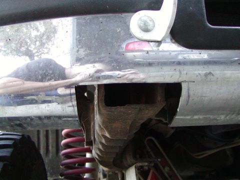1995 Ford Bronco - Close-up view of a vehicle's undercarriage, highlighting suspension components and a reflective bumper.
