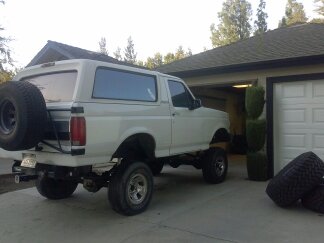 1995 Ford Bronco - Rear view of a white Ford Bronco, parked outside a residential garage.