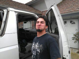 1995 Ford Bronco - A man poses next to a white pickup truck with its door open.