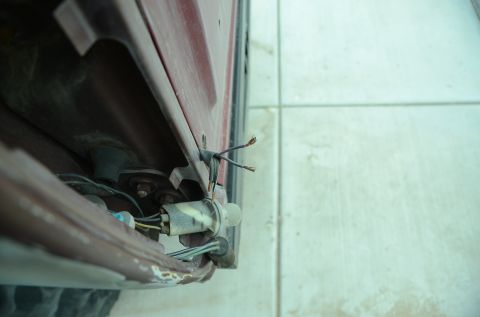 1979 Ford Bronco - Close-up view of the exposed wiring harness and bulb socket for a vehicle's tail light assembly.