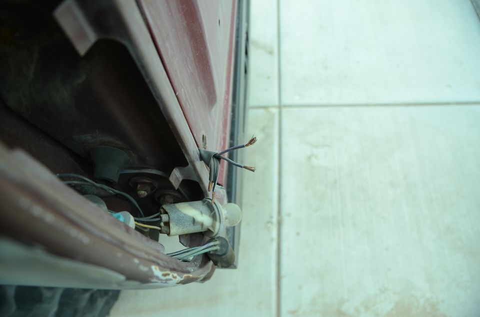 Red vehicle's exposed tail light wiring harness and bulb socket