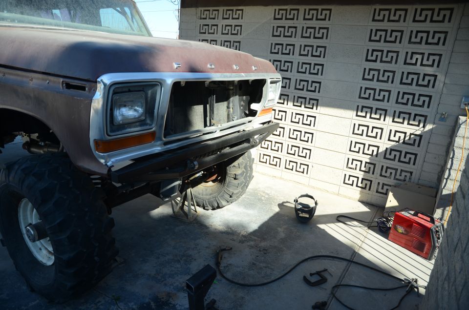 Brown 1978 Ford Bronco front end with chrome grille and square headlights, lifted with large tires