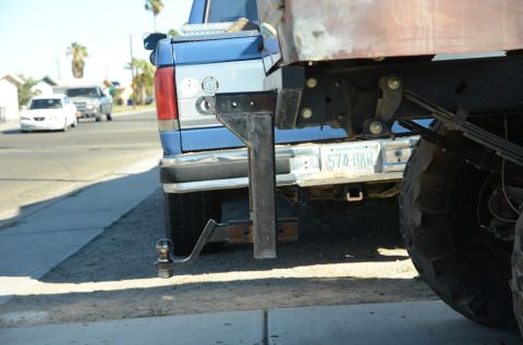 1979 Ford Bronco - Custom hitch assembly on the rear of a blue pickup truck, with other vehicles on the street.
