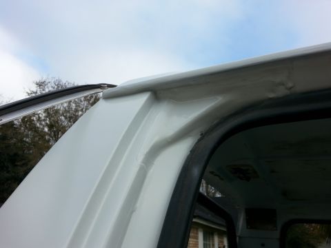 1992 Ford Bronco - Close-up view of the drip rail on a white SUV, showing areas of repair and potential rust.