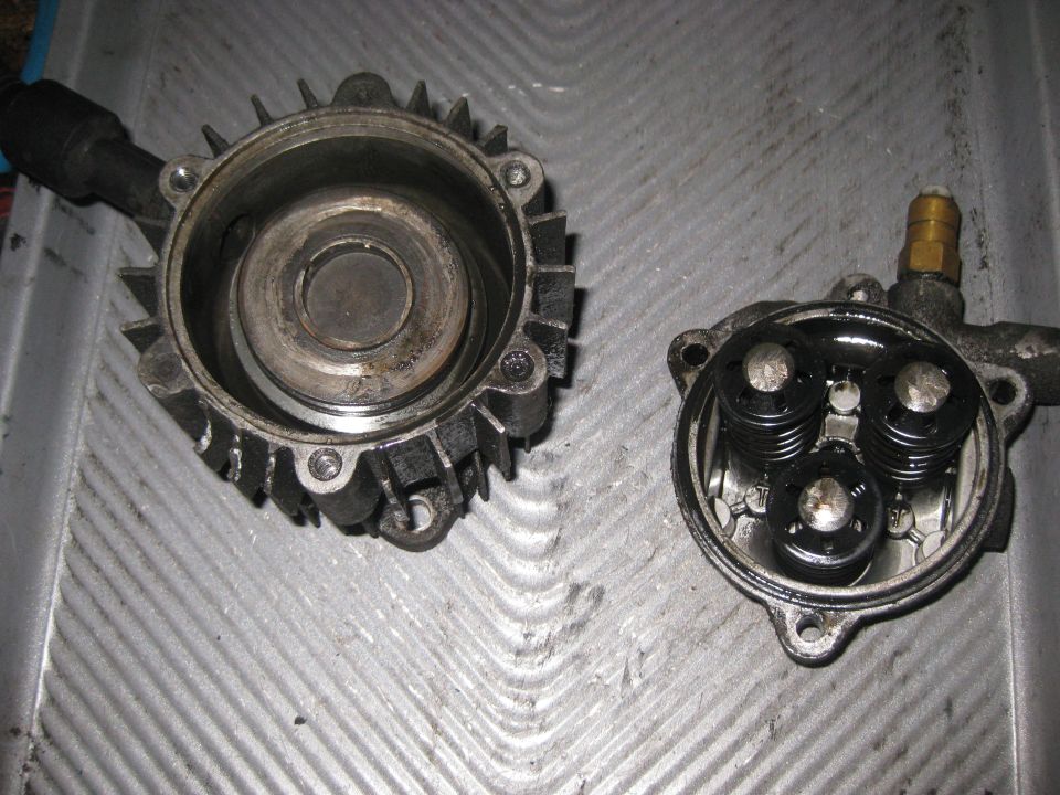 Two disassembled pump components, one with a ribbed housing and internal cylinder, the other showing three spring-loaded plungers