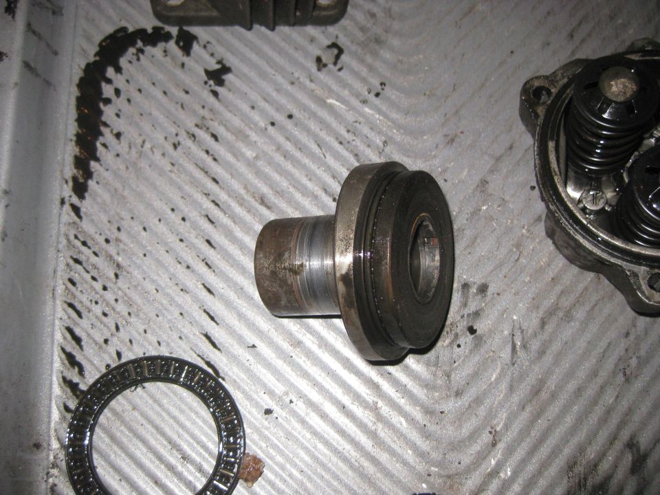 Metal shaft with a bearing and part of an engine assembly on a ribbed metal surface