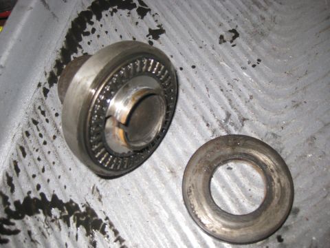 2006 Honda RANCHER - A close-up view of a bearing and washer assembly, likely a mechanical part, resting on a surface with oil residue.
