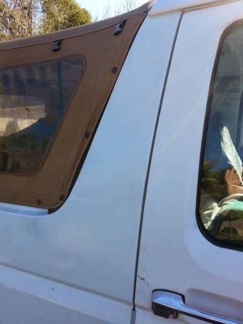 1992 Ford Bronco - Close-up of the side of a 1992 Ford Bronco, showing the door and soft top.
