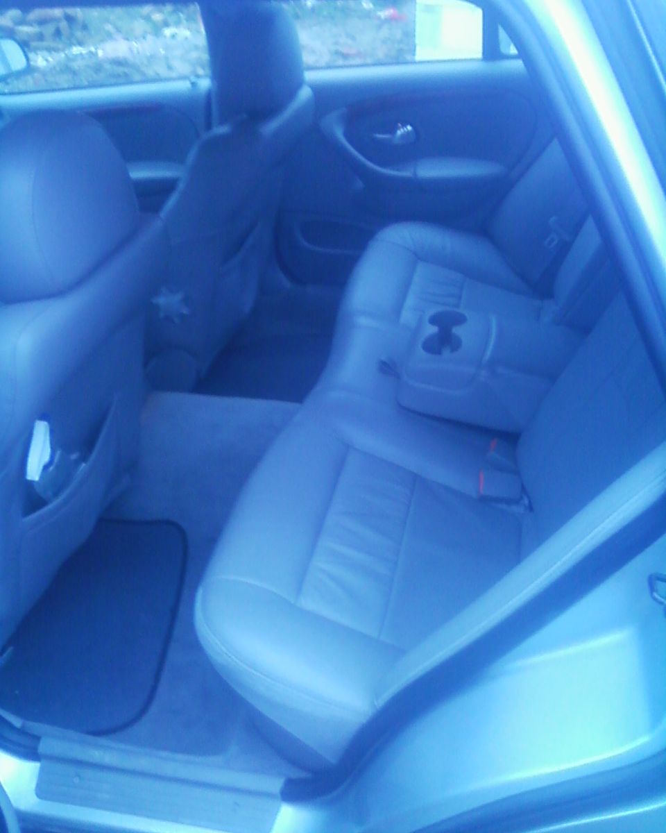 Back seat and door panel of a car. Has a cup holder in the center console
