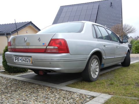 1999 Ford Fairlane - A silver sedan is parked in a driveway with a house and solar panels in the background.