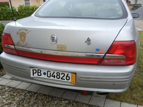 1999 Ford Fairlane - Rear view of a silver sedan with various stickers on its trunk and a license plate.