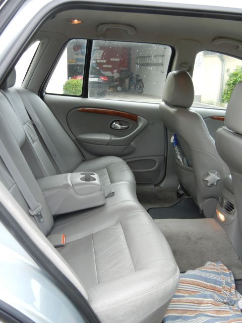 1999 Ford Fairlane - The interior of a car shows the rear seats, door panel, and floor with a blanket.