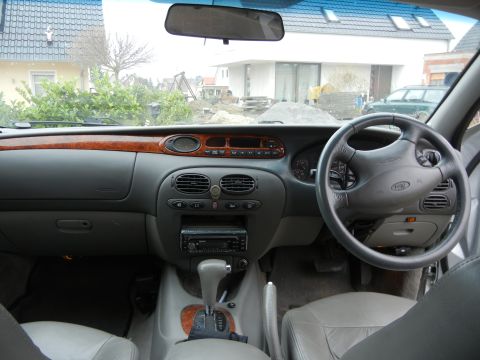 1999 Ford Fairlane - Interior view of a car's dashboard, steering wheel, and center console.