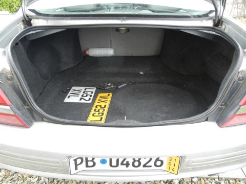 1999 Ford Fairlane - The interior of a car trunk is shown, with two license plates and a bottle visible.