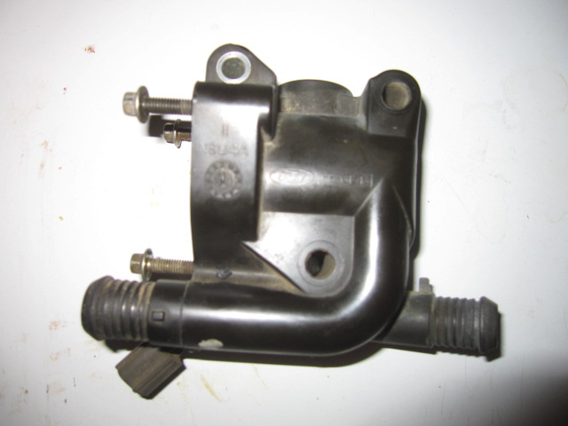 Black plastic thermostat housing with metal bolts and hose connections
