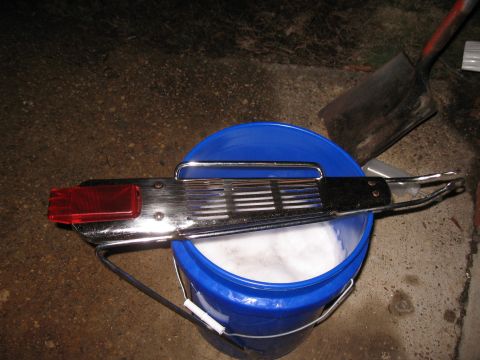 Chrome luggage rack with red reflector on blue bucket