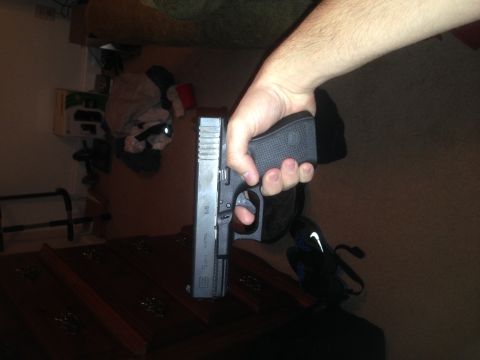 1996 Ford Bronco - A hand grips a pistol, with a Nike bag visible in the background.