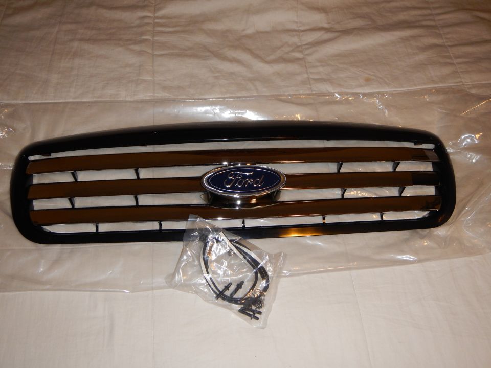 Black Ford grille with chrome bars and blue oval badge on white cloth