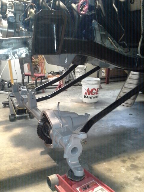 1968 Ford Bronco - The front axle assembly of a vehicle is shown, painted gray and supported by jacks.