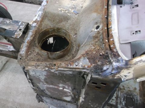 1967 Ford Mustang - Close-up of a heavily rusted car frame section, showing a circular opening and welding repairs. Supermotors.net watermark is visible.