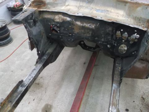 1967 Ford Mustang - The firewall and frame rails of a car are visible, showing signs of rust and repair work.
