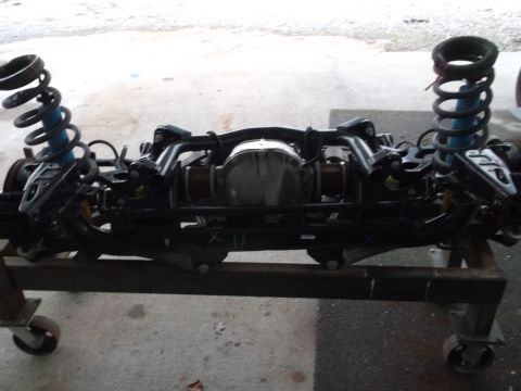 1967 Ford Mustang - Rear axle assembly with suspension components, including coil springs and shock absorbers, mounted on a stand.