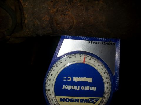 1996 Ford Bronco - An angle finder tool is used to measure the angle of a rusty metal part.