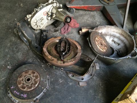 1997 Dodge 3500 - Disassembled transmission components, including a clutch and flywheel, are laid out on a workshop floor.