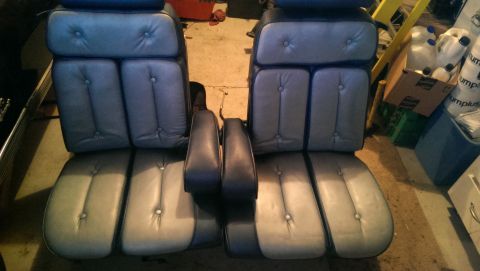 1975 Ford Ranchero - Two bucket car seats are shown in a garage setting, with various items in the background.