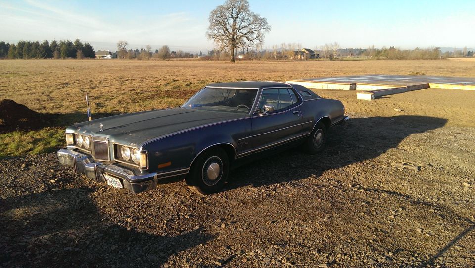 Dark blue 1974 Ford Elite coupe parked on gravel lot